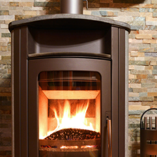 Freestanding multi-fuel burner with visible flames against a tiled backdrop
