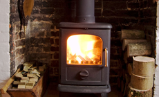 Lit stove in a brick fireplace recess
